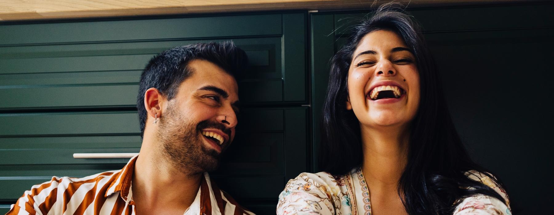 a man and woman laughing on kitchen floor