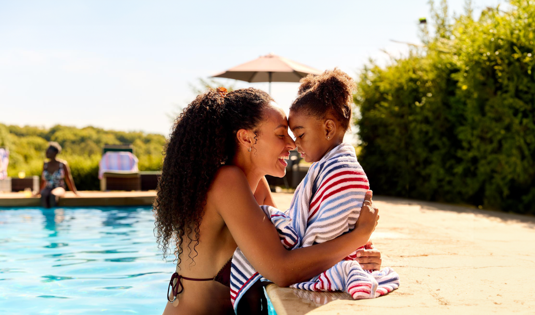 mother hugs her child at the pool